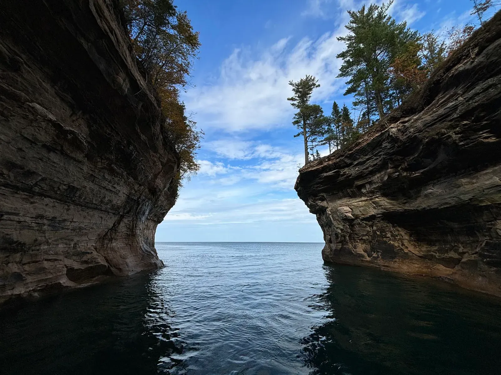 A narrow channel between sandstone cliffs opening onto a lake.